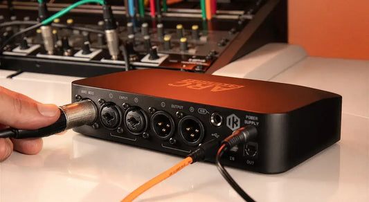 Close-up of IK ARC Studio+ audio interface connections with cables plugged in.